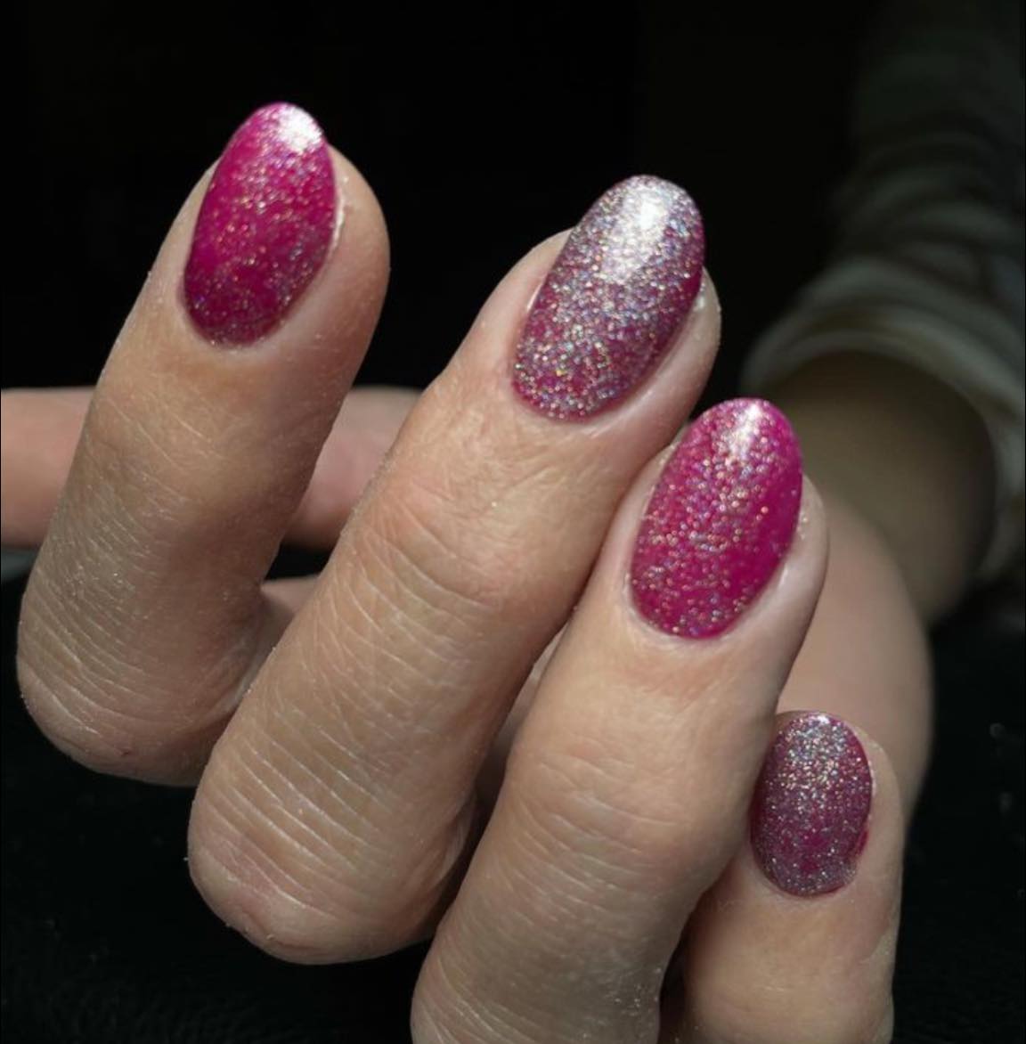 Magenta glitternagels met een zilveren accentnagel