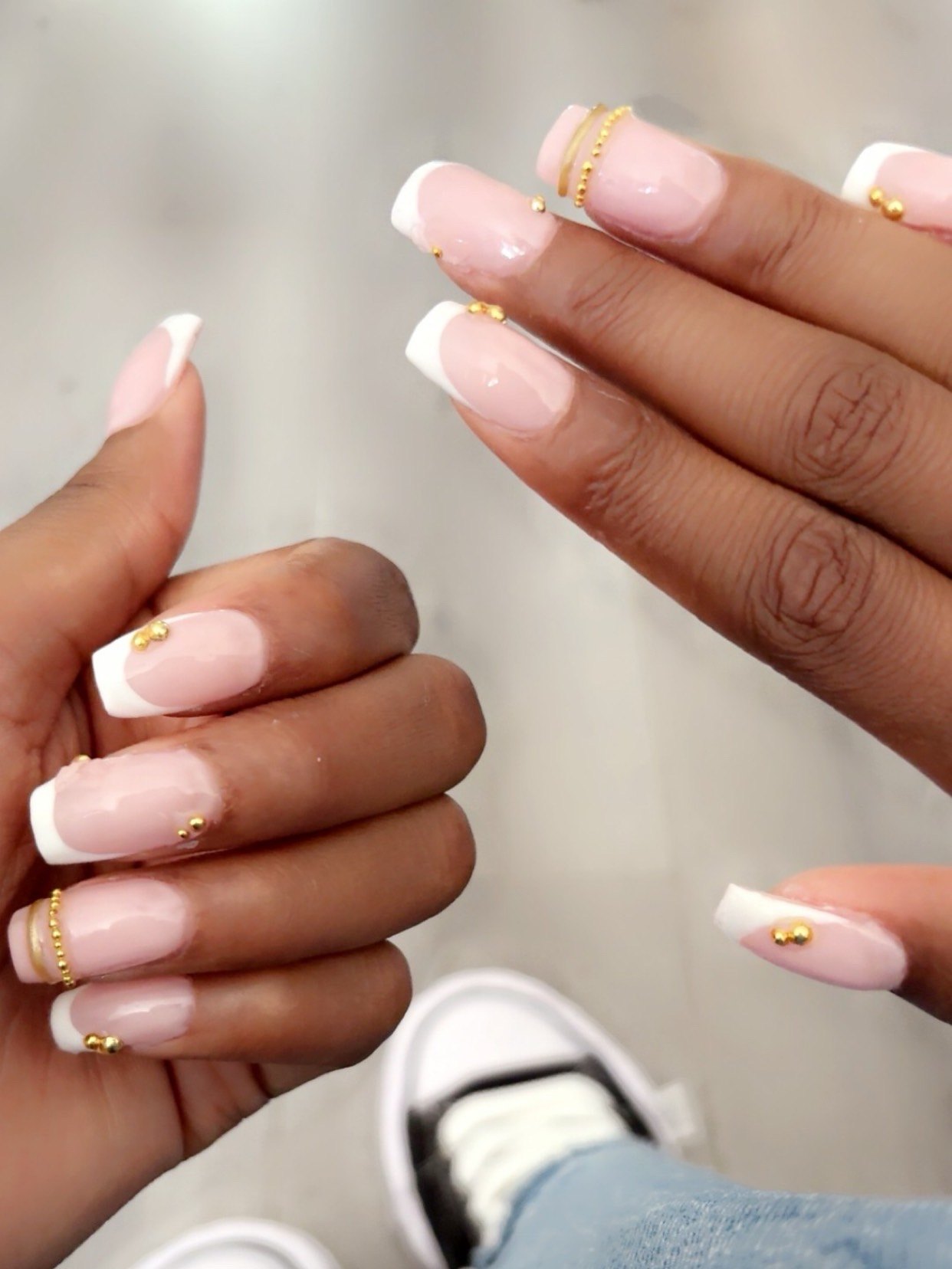 Nude nagels met witte french en gouden steentjes