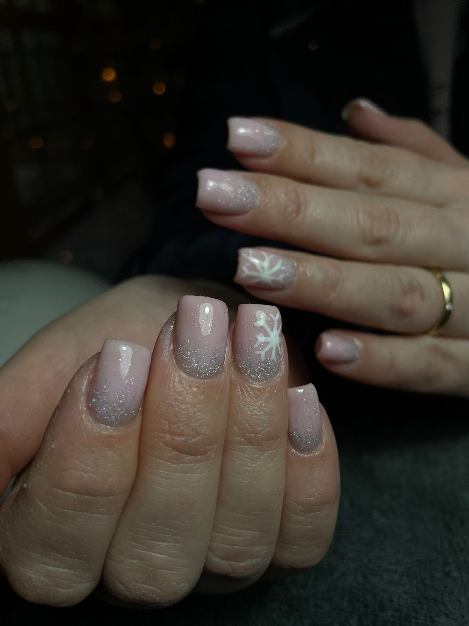 Korte nagels in glitter nude met een witte sneeuwvlok